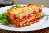 A plate of lasagna with sauce and cheese.